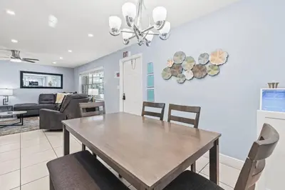 a dining room and living room with a table and chairs at Beach Pool & Las Olas Getaway Fort Lauderdale in Fort Lauderdale