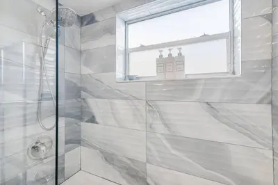 a bathroom with a glass shower with a window at Beach Pool & Las Olas Getaway Fort Lauderdale in Fort Lauderdale