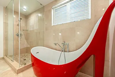 a bathroom with a tub with a red high heel at Walk to Hollywood Beach Luxury Family Getaway! in Hollywood