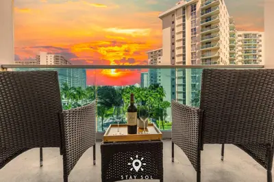 a room with a table with a bottle of wine and two chairs at Modern Hollywood Beach Escape - City Views in Hollywood