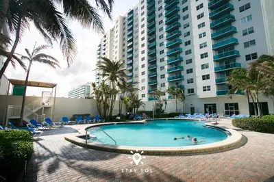 a swimming pool in front of a large building at Modern Hollywood Beach Escape - City Views in Hollywood