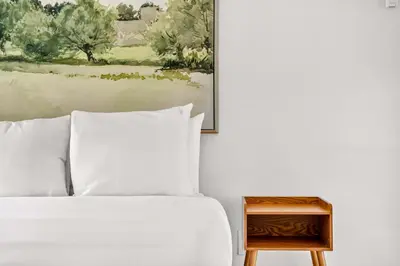 a bedroom with a bed and a painting and a nightstand at Sleek Kitchenette & Queen Bed in Fort Lauderdale