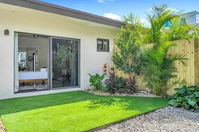 a house with a green lawn in front of it at Sleek Kitchenette & Queen Bed in Fort Lauderdale