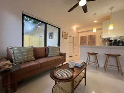 a living room with a couch and a table and a kitchen at The Modern Oasis Queen Studio with Kitchen in Fort Lauderdale