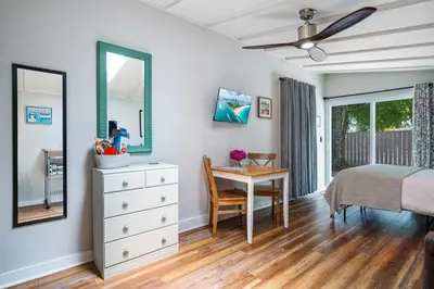 a bedroom with a bed and a desk and a table at Jungle Fortress in Fort Lauderdale
