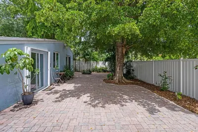 a driveway with a tree and a fence at Jungle Fortress in Fort Lauderdale