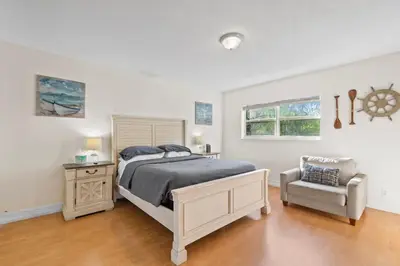 a bedroom with a bed and a chair at Beachside Las Olas Getaway Oasis with Pool in Fort Lauderdale
