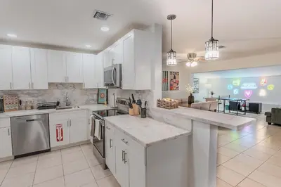 a kitchen with white cabinets and a counter top at Villa Hollywood Pool Trampoline BBQ Hard Rock in Hollywood