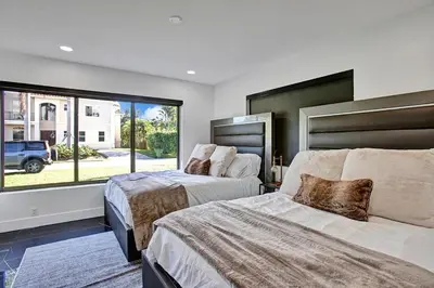 a bedroom with two beds and a large window at Coral Lane by Rove Travel - Home with Pool & BBQ in Fort Lauderdale