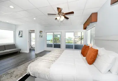 a white bedroom with a bed and a ceiling fan at Coastal Collection in Fort Lauderdale