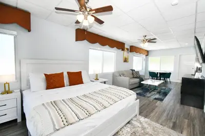 a bedroom with a white bed with a ceiling fan at Coastal Collection in Fort Lauderdale