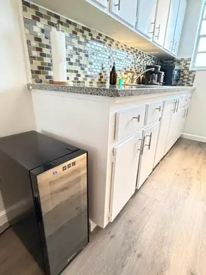 a kitchen with white cabinets and a black dishwasher at Sunny Miami Beach Getaway , Steps from the Ocean! in Miami Beach