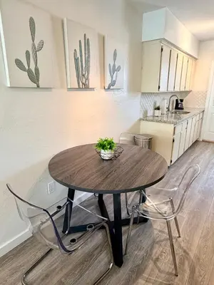 a kitchen with a wooden table and two chairs at Sunny Miami Beach Getaway , Steps from the Ocean! in Miami Beach