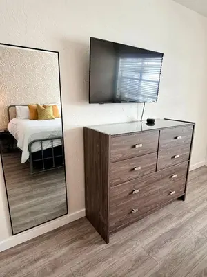a bedroom with a dresser with a mirror and a bed at Sunny Miami Beach Getaway , Steps from the Ocean! in Miami Beach