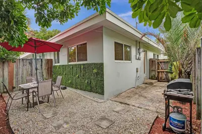 a house with a table and a grill in front of it at Casa Sol in Fort Lauderdale