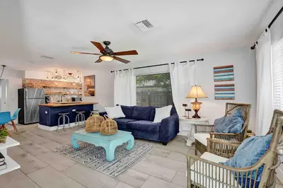 a living room with a blue couch and a ceiling fan at Casa Sol in Fort Lauderdale