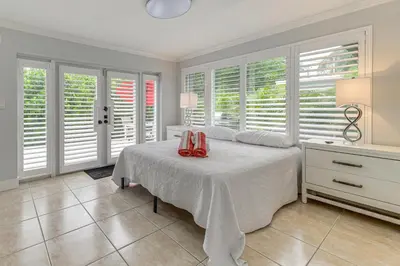 a bedroom with a bed with red shoes on it at Walkable Island City Oasis with Private Heated Pool! in Fort Lauderdale