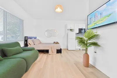 a living room with a couch and a tv at Miami Modern Studio minutes to Wynwood & Downtown in Miami
