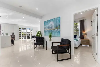 a living room with a bed and a table and chairs at Renovated house w private heated pool grill in Hollywood