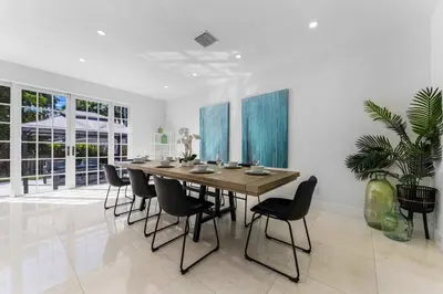 a dining room with a large wooden table and chairs at Renovated house w private heated pool grill in Hollywood
