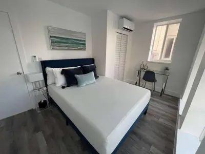 a bedroom with a large white bed with black pillows at KING OF MIAMI - 2bd Retreat 1 mile from Brickell in Miami