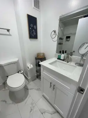 a bathroom with a toilet and a sink and a mirror at KING OF MIAMI - 2bd Retreat 1 mile from Brickell in Miami