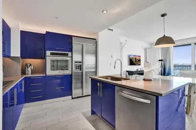 a kitchen with blue cabinets and stainless steel appliances at 2BR W Residence 18th Floor, Ocean, Inter-coastal, & City Views in Fort Lauderdale