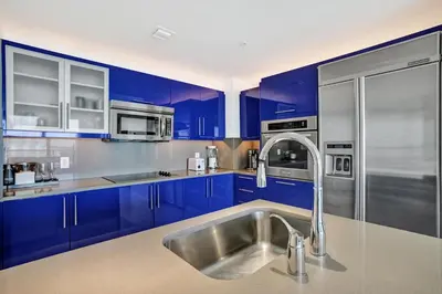 a kitchen with blue cabinets and a stainless steel sink at 2BR W Residence 18th Floor, Ocean, Inter-coastal, & City Views in Fort Lauderdale