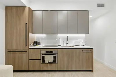 a kitchen with wooden cabinets and a sink at 72 Park - Miami Beach Condo w Beach Access in Miami Beach