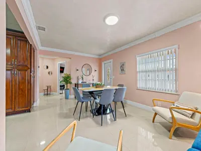 a dining room with pink walls and a table and chairs at Tropical Bay House-Near By Brickell, Wynwood and South Beach in Miami