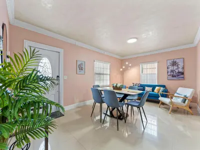 a dining room with a table and chairs and a couch at Tropical Bay House-Near By Brickell, Wynwood and South Beach in Miami