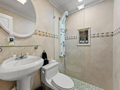 a bathroom with a sink and a toilet and a mirror at Tropical Bay House-Near By Brickell, Wynwood and South Beach in Miami