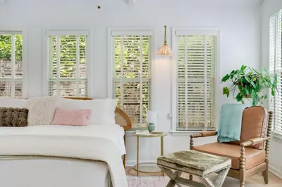 a bedroom with a bed and a chair and windows at Garden Grove- Miami Home with Private Pool in Miami