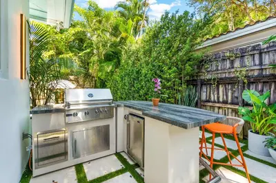 a outdoor kitchen with a stove and a table at Garden Grove- Miami Home with Private Pool in Miami