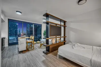 a bedroom with a bed and a desk with a television at Alea Miami Designer Studios Downtown in Miami
