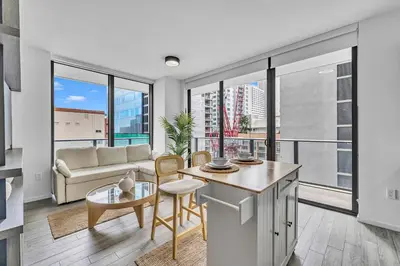 a kitchen and living room with large windows at Alea Miami Designer Studios Downtown in Miami