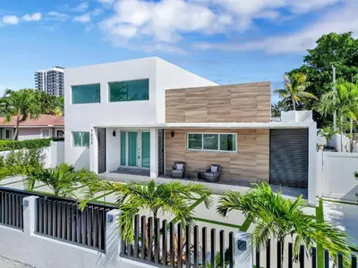 a white house with palm trees in front of it at Villa Coral Bay in Miami Beach
