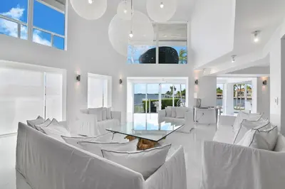 a room with white chairs and a table and windows at Villa Moonlight Haven in Miami Beach
