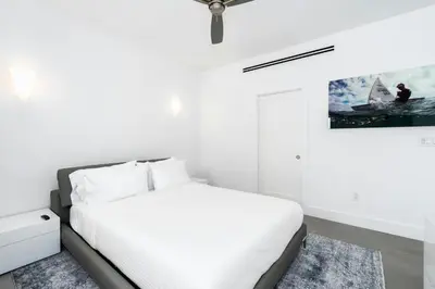a white bedroom with a bed and a painting on the wall at Villa Modern Miami glamour in Miami