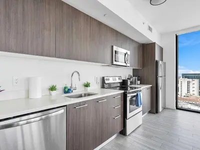 a kitchen with stainless steel appliances and a large window at X Lounge VII-Private Sky Residence in Miami