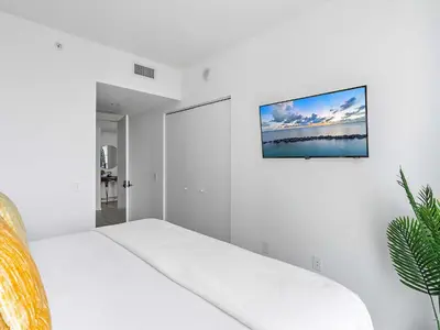 a white bedroom with a bed and a picture on the wall at X Lounge VII-Private Sky Residence in Miami