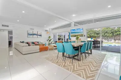 a living room with a couch and a table and chairs at 5BR Villa with Heated Pool, Firepit and 10mins to Beach in Highland Lakes