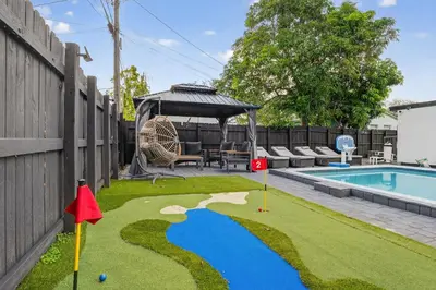 a miniature golf course in the backyard of a house at Heated Pool Home - Mini Golf & Soccer & Firepit in Hollywood