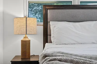 a lamp on a table next to a bed at Heated Pool Home - Mini Golf & Soccer & Firepit in Hollywood