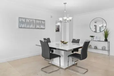 a dining room with a white table and black chairs at Oceanfront corner unit in Hollywood