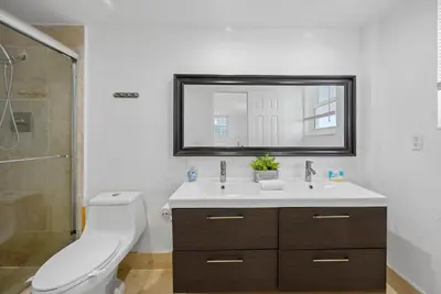 a bathroom with a sink and a toilet and a mirror at Oceanfront corner unit in Hollywood