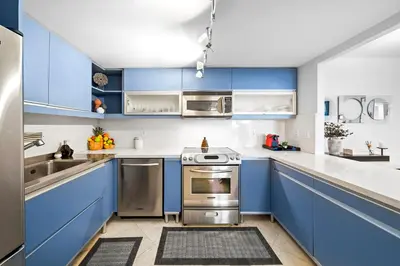 a blue kitchen with stainless steel appliances and blue cabinets at Roney Palace 408 in Miami Beach