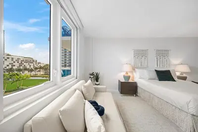 a white bedroom with a bed and a large window at Roney Palace 408 in Miami Beach