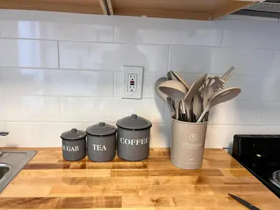 three trash cans on a kitchen counter with utensils at Miami Luxury Studio, Close to Wynwood and Beach in Biscayne Park