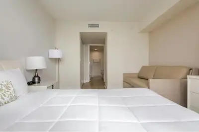 a white bedroom with a large bed and a couch at Beachwalk Resort in Hallandale Beach